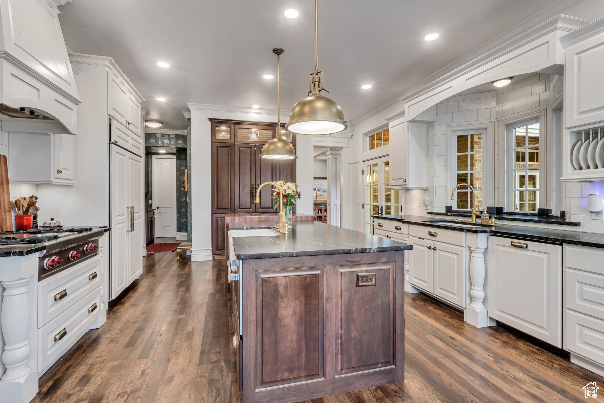 Kitchen featuring white cabinets, sink, dark wood flooring, and a center island with sink