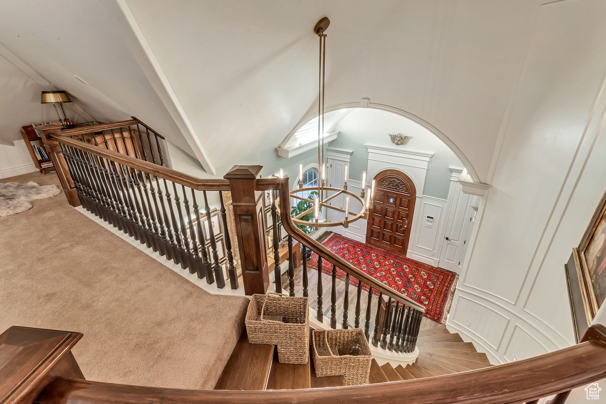 Stairs featuring light carpet and high vaulted ceiling