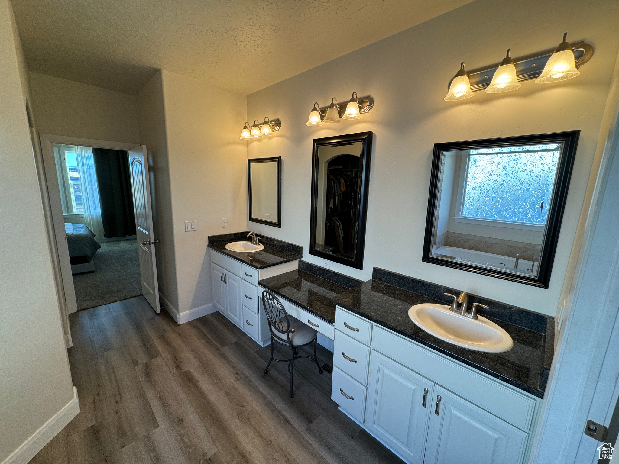 Master Bathroom featuring hardwood / wood-style floors, dual bowl vanity, and a textured ceiling
