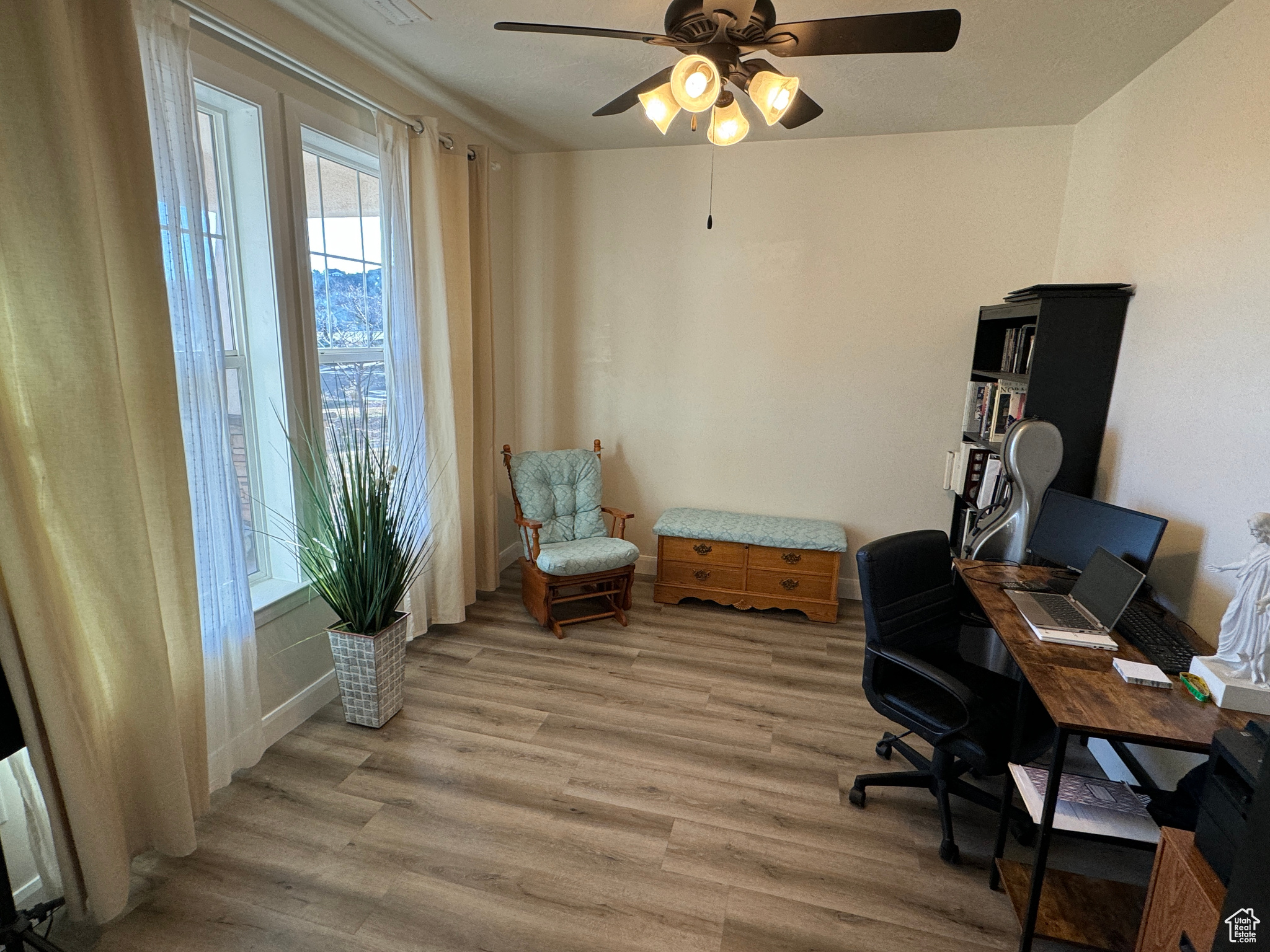 Office space with light hardwood / wood-style floors and ceiling fan
