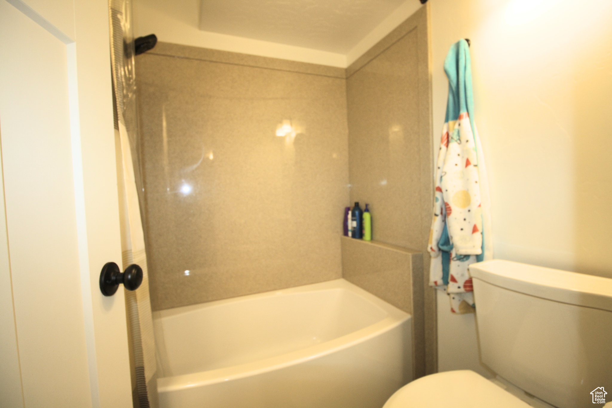Bathroom with Marble shower / bathtub combination and toilet