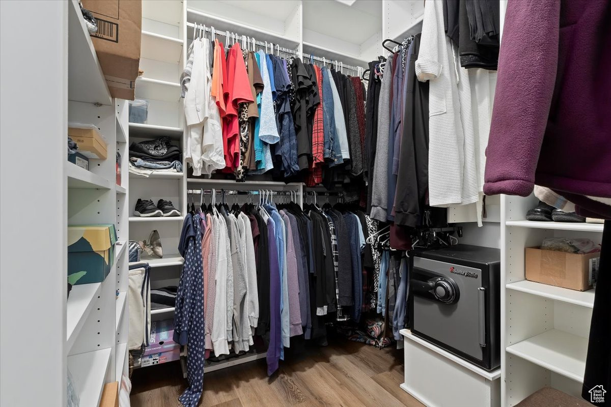 Spacious master closet with light wood-type flooring