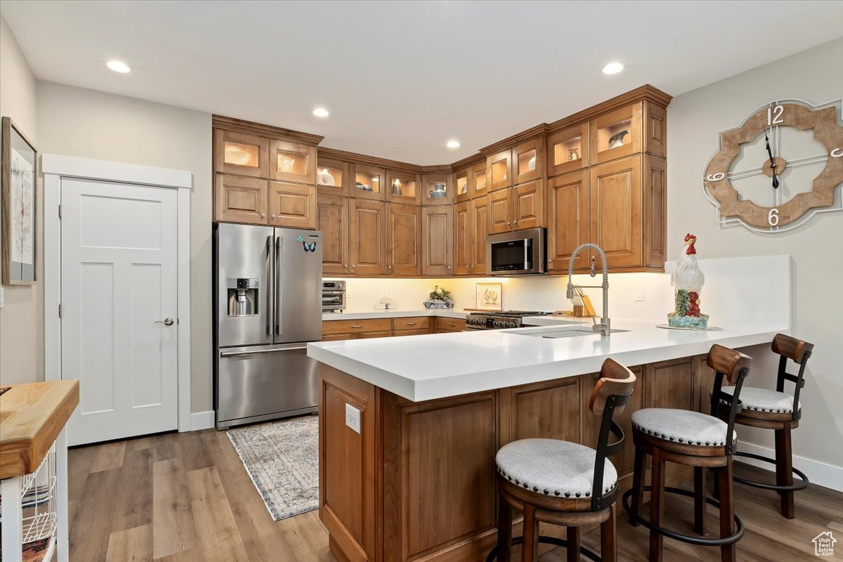 Kitchen featuring a kitchen bar, sink, and appliances with stainless steel finishes