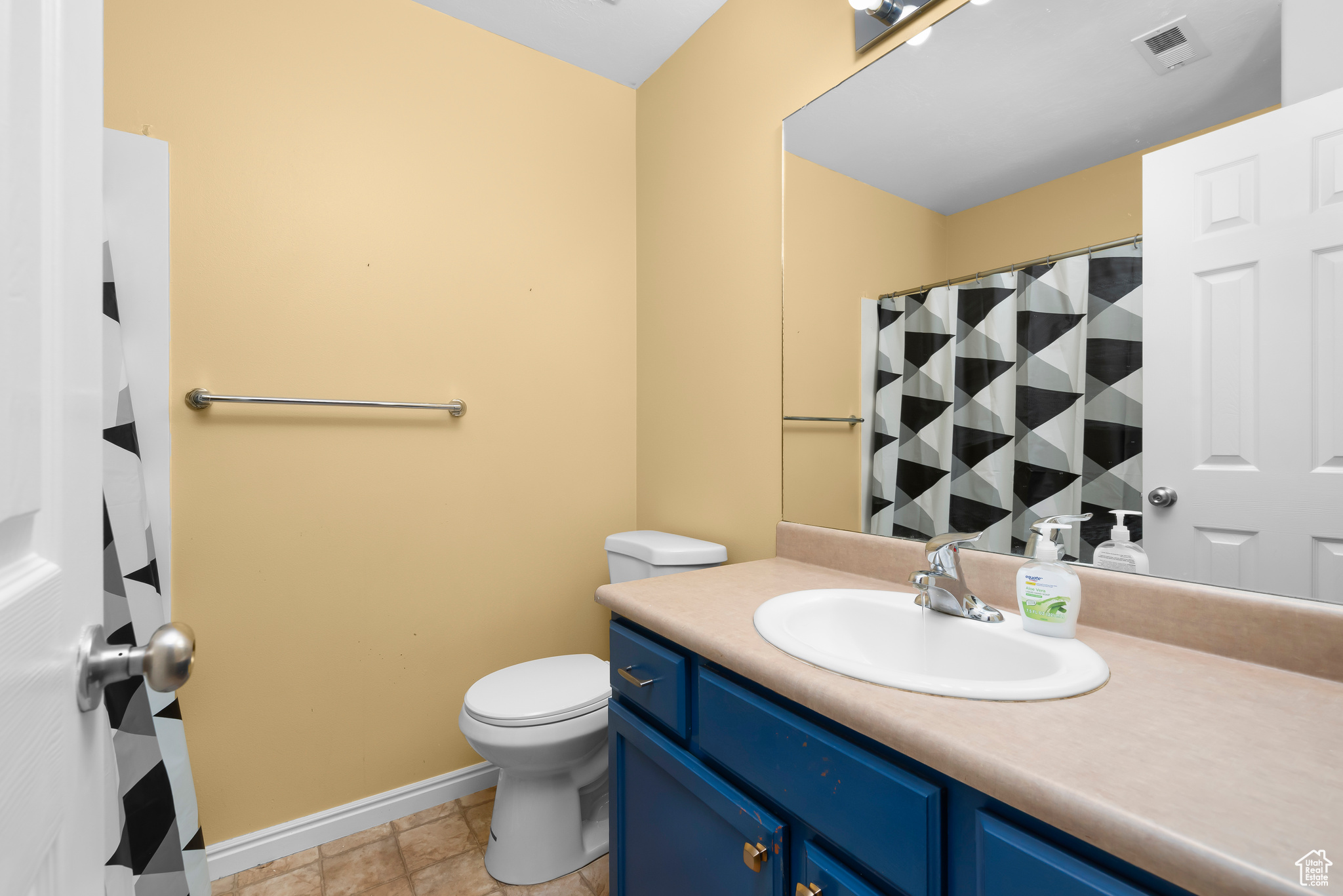 Bathroom with vanity with extensive cabinet space, and toilet