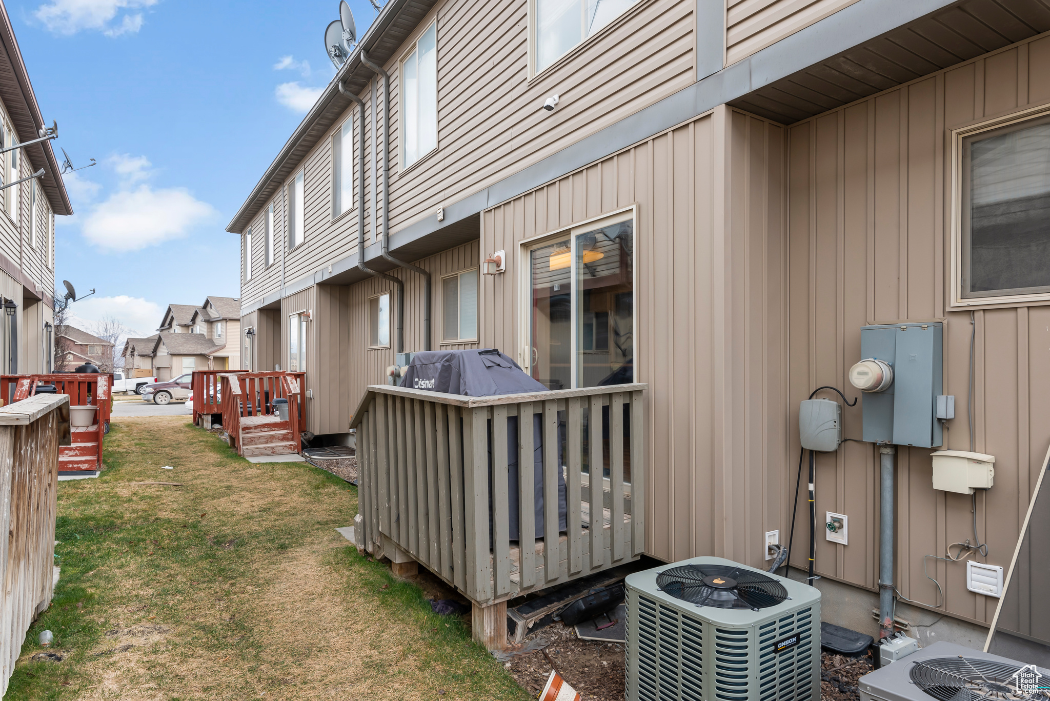 View of side of home featuring NEW central AC, a yard, and a wooden deck