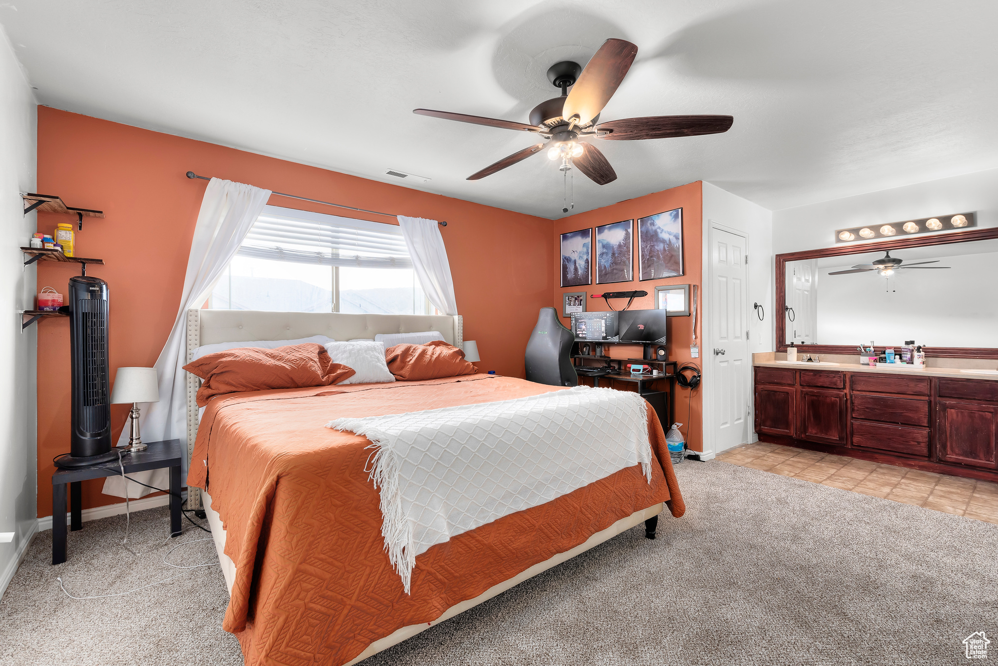 Master Bedroom featuring light carpet, ensuite bath, and ceiling fan