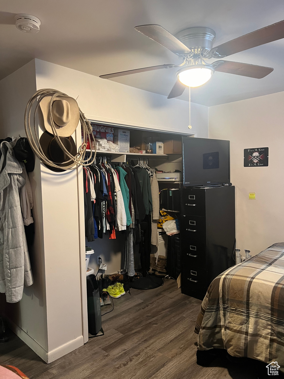 Bedroom with ceiling fan, a closet, and dark hardwood / wood-style floors