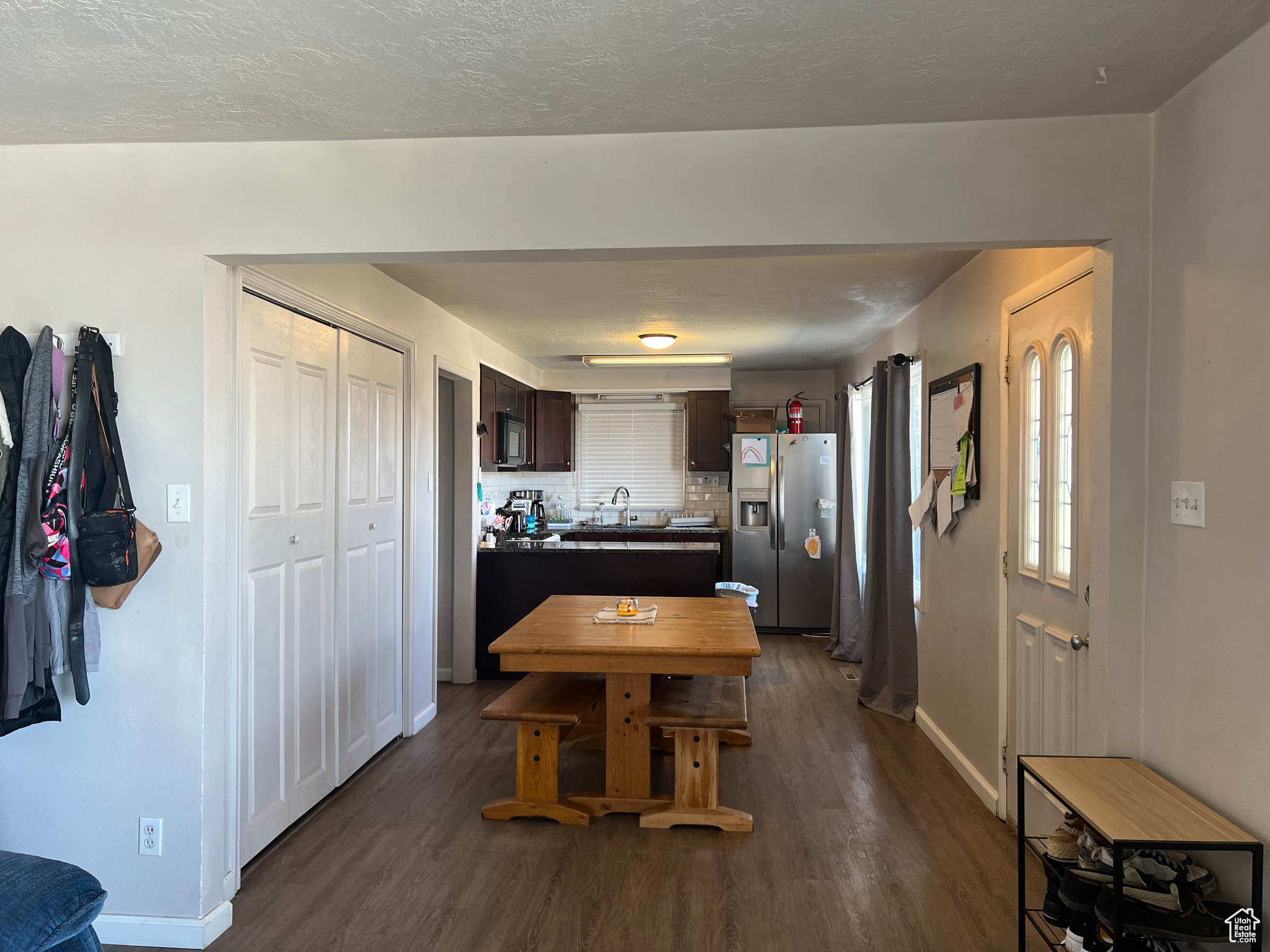 Kitchen featuring tasteful backsplash, sink, stainless steel fridge, dark hardwood / wood-style floors, and dark brown cabinets