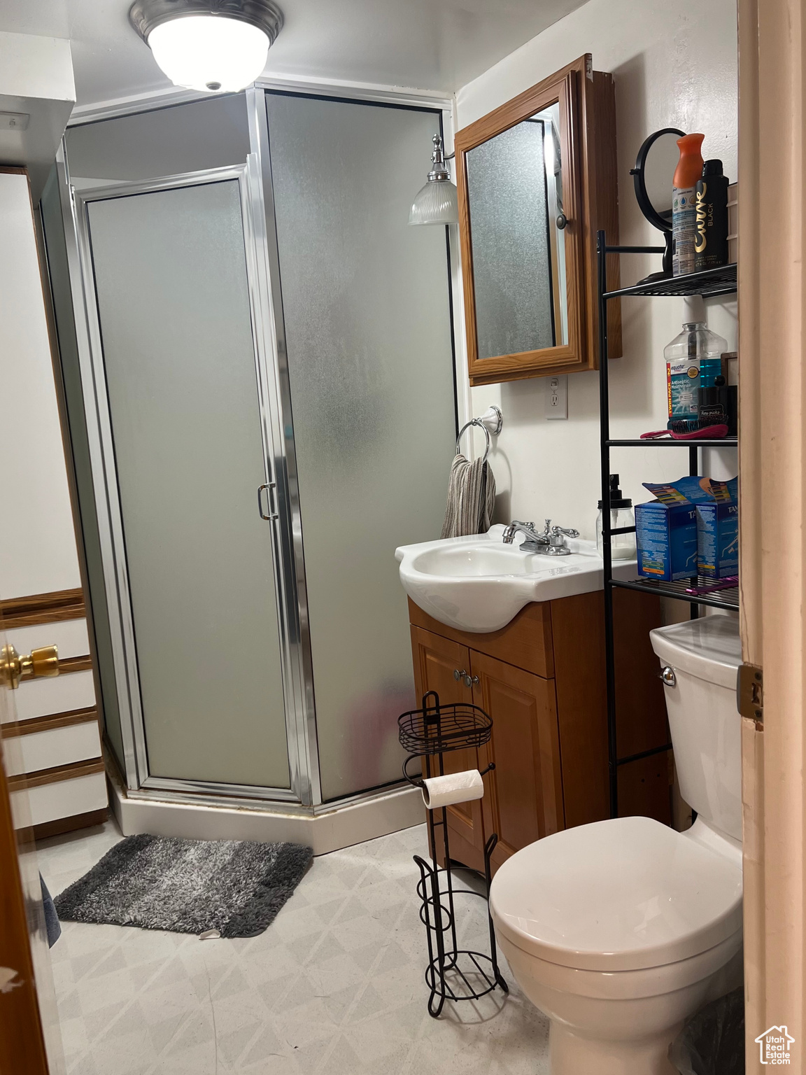 Bathroom featuring tile flooring, an enclosed shower, toilet, and vanity