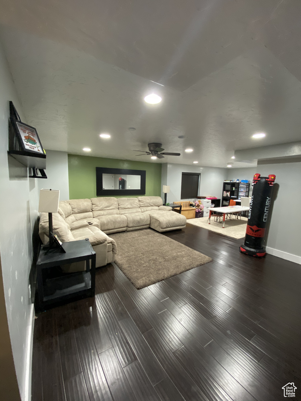 Living room featuring dark wood-type flooring and ceiling fan
