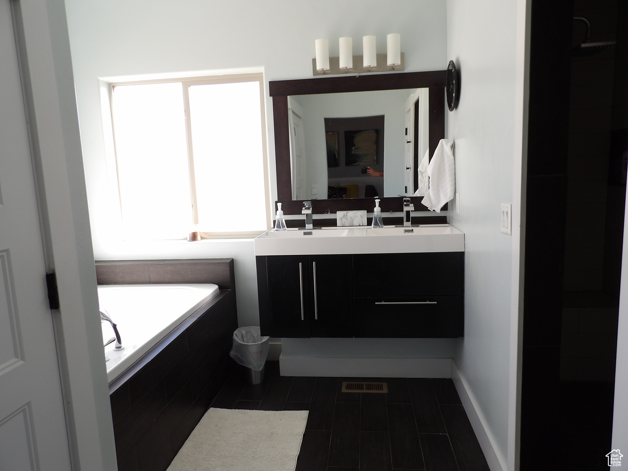 Bathroom with vanity, tile flooring, and tiled tub