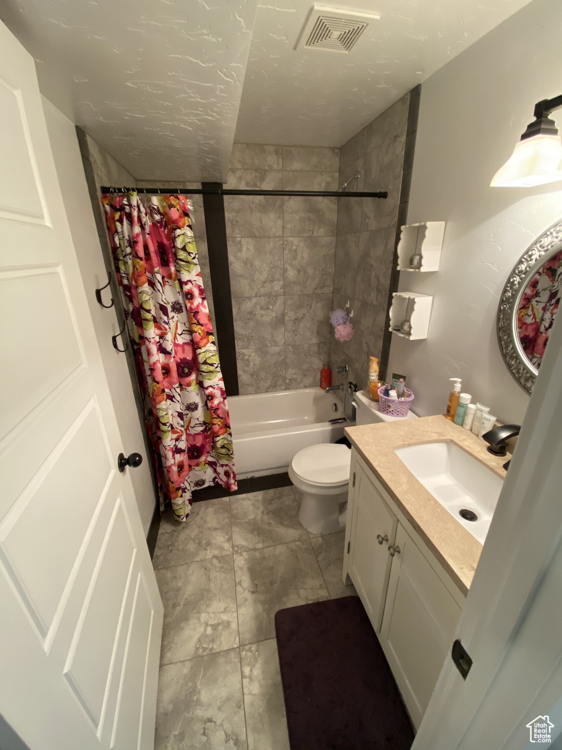 Full bathroom with vanity, shower / bath combo, tile floors, and toilet
