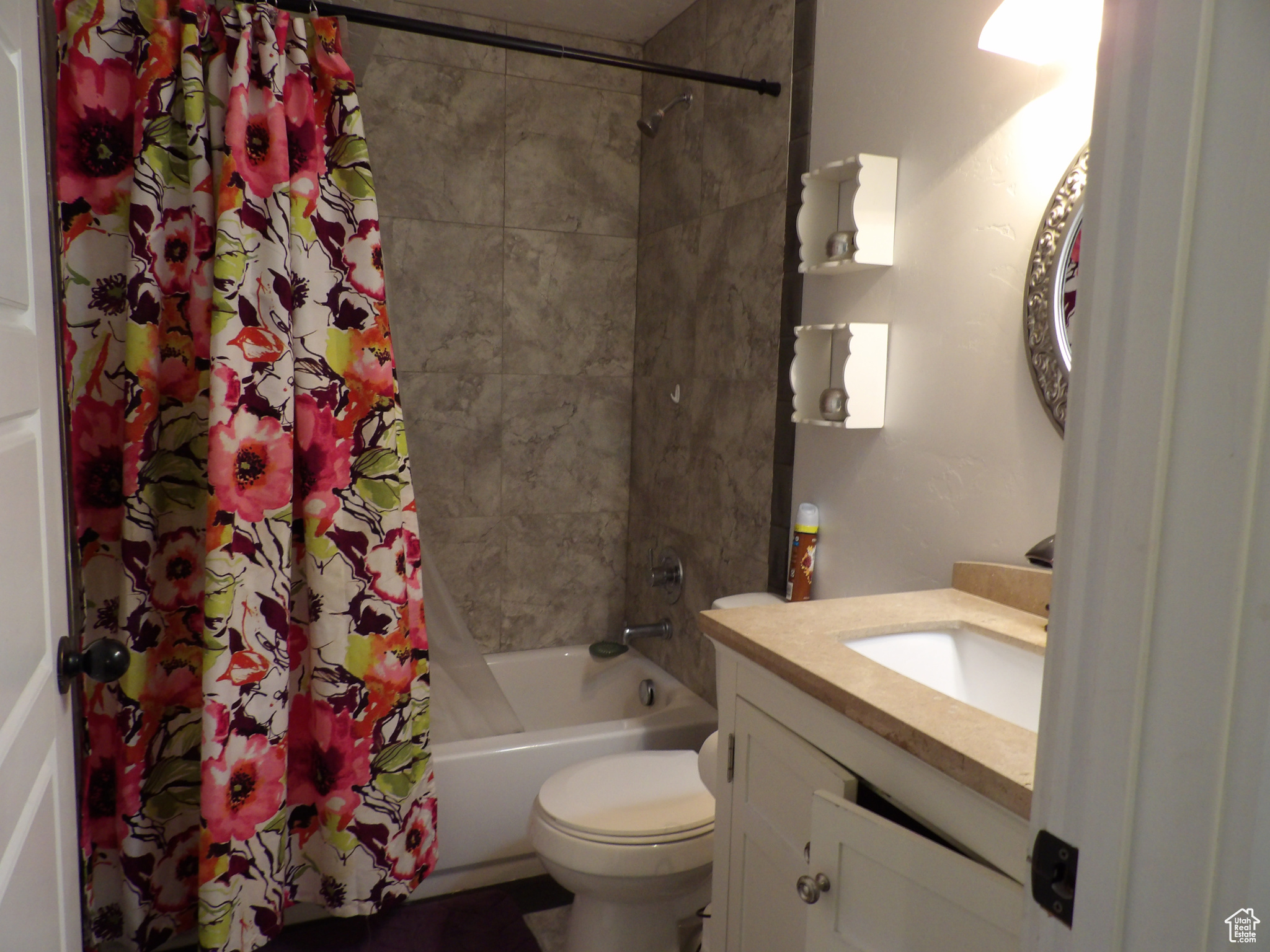 Full bathroom with vanity, shower / tub combo with curtain, and toilet
