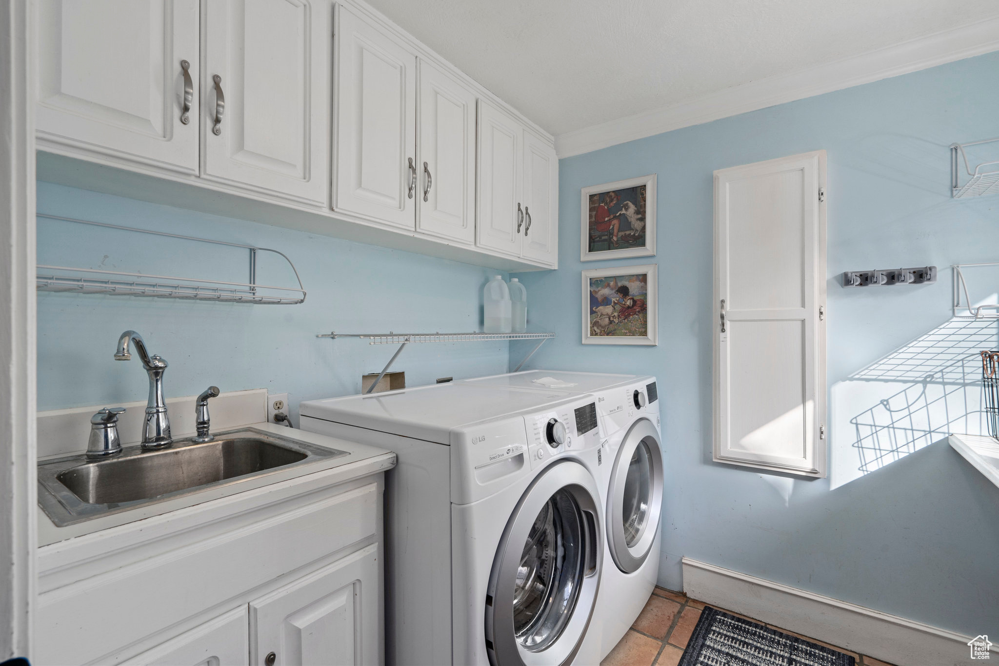 Laundry room with washer and clothes dryer, cabinets, crown molding, sink, and light tile floors