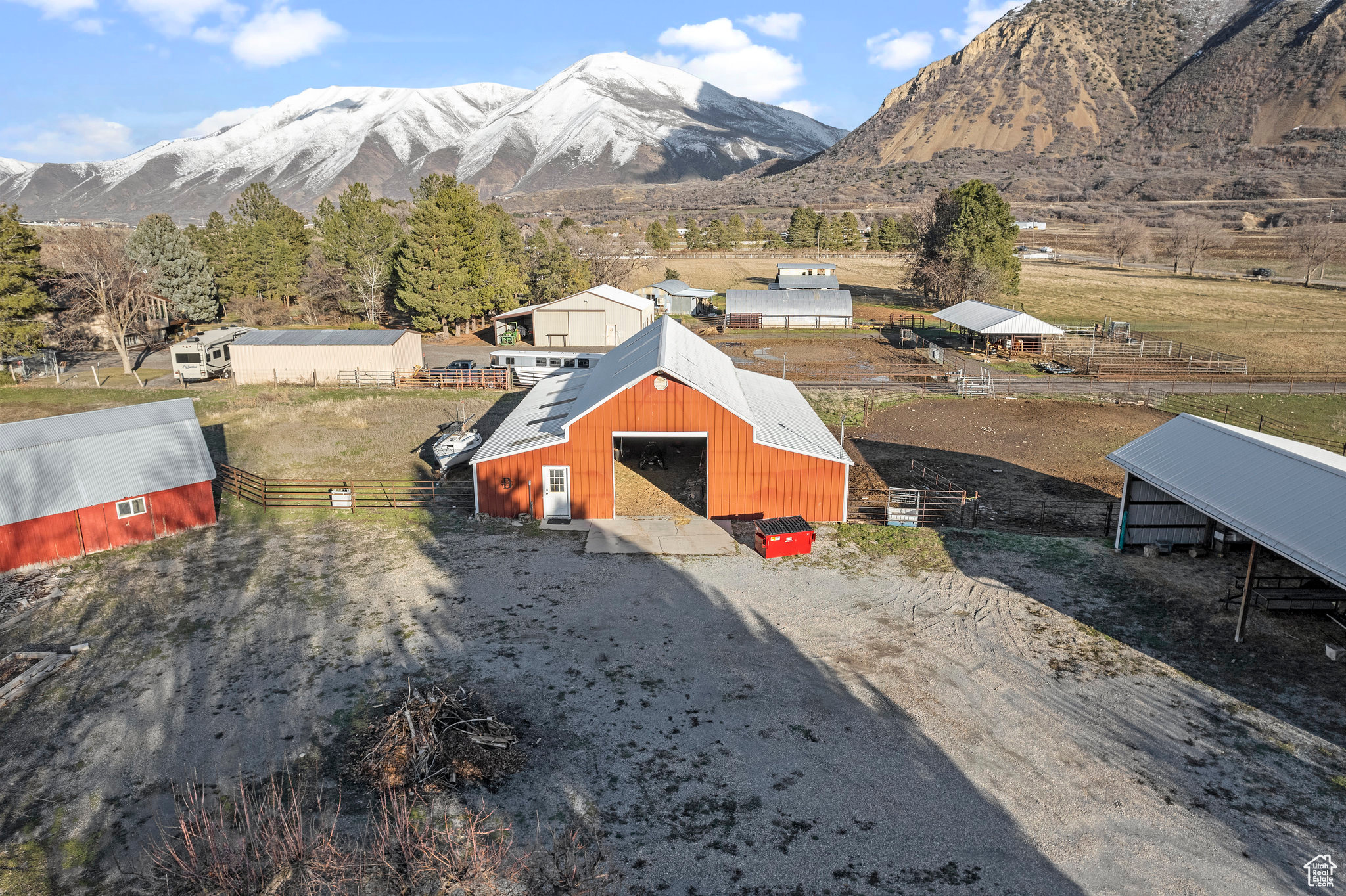 View of yard with a mountain view and an outdoor structure. Building to the left is a huge chicken coop, main barn/horse stable in the middle and a machine shed on the right.