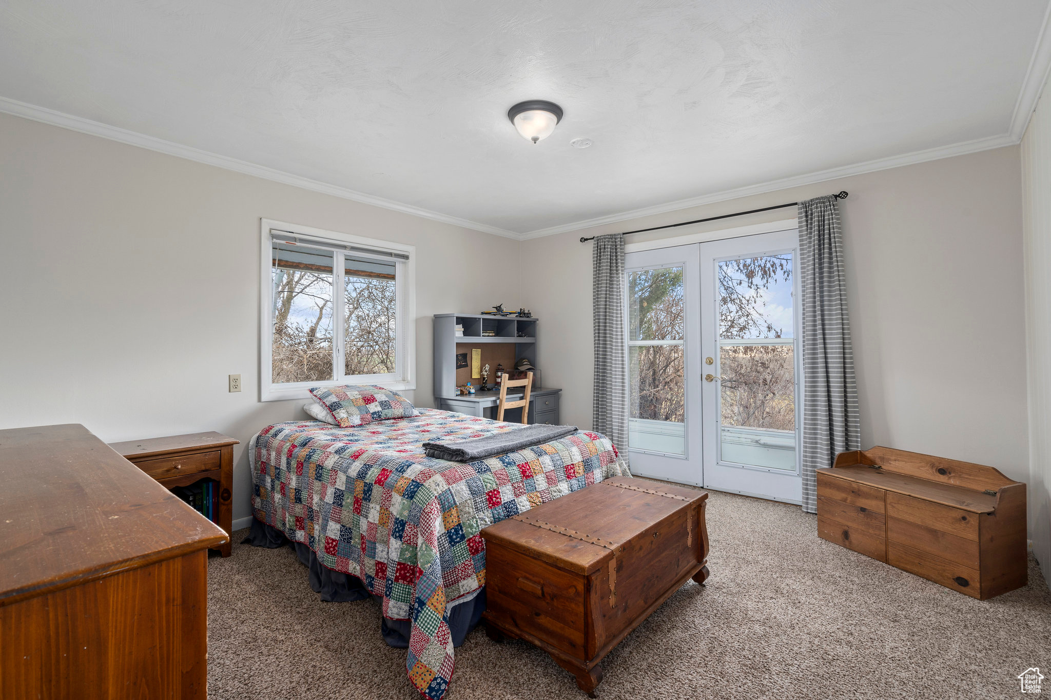 Bedroom with access to exterior, crown molding, light colored carpet, and french doors that open onto Trex deck on the north side of the home overlooking the riverbottoms area.