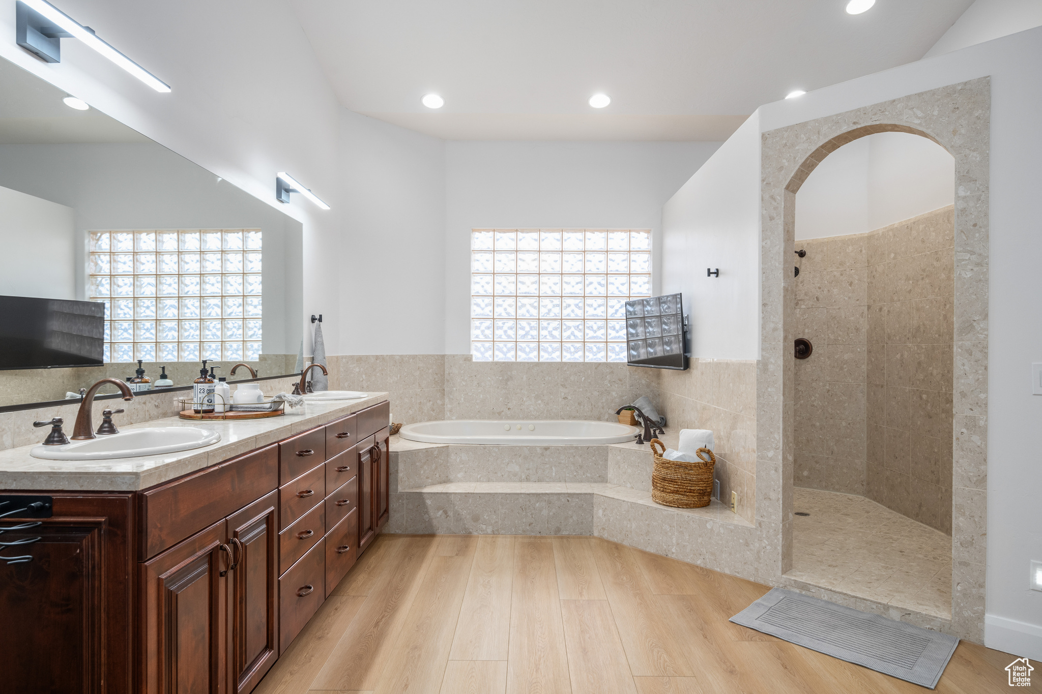 Bathroom with a wealth of natural light, dual vanity, separate shower and tub, and hardwood / wood-style floors