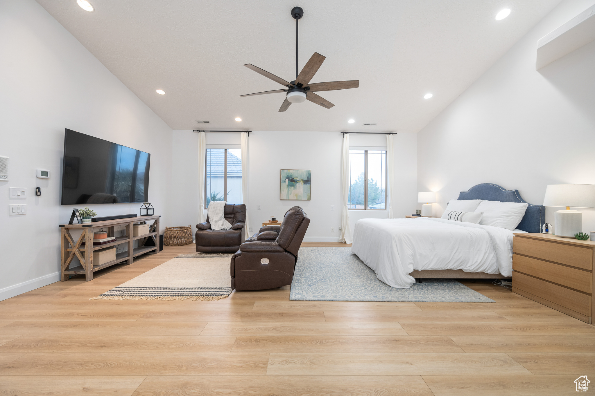 Bedroom with ceiling fan, light wood-type flooring, and lofted ceiling