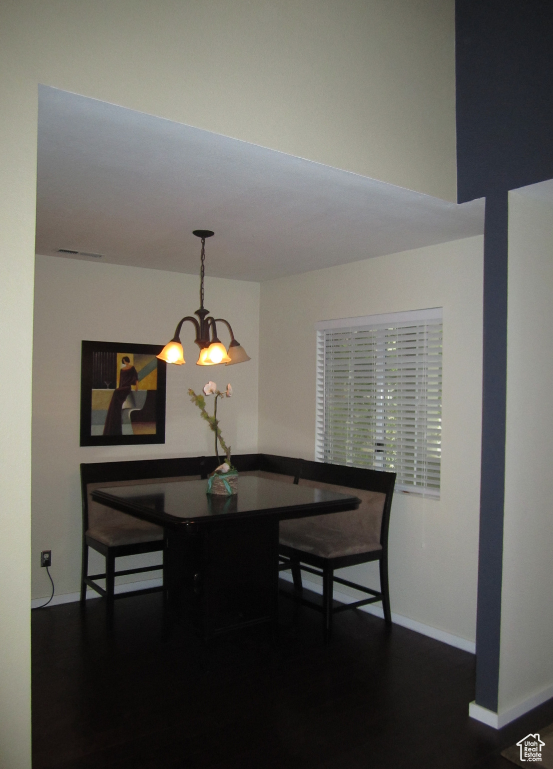 Dining area with dark hardwood / wood-style flooring and a notable chandelier