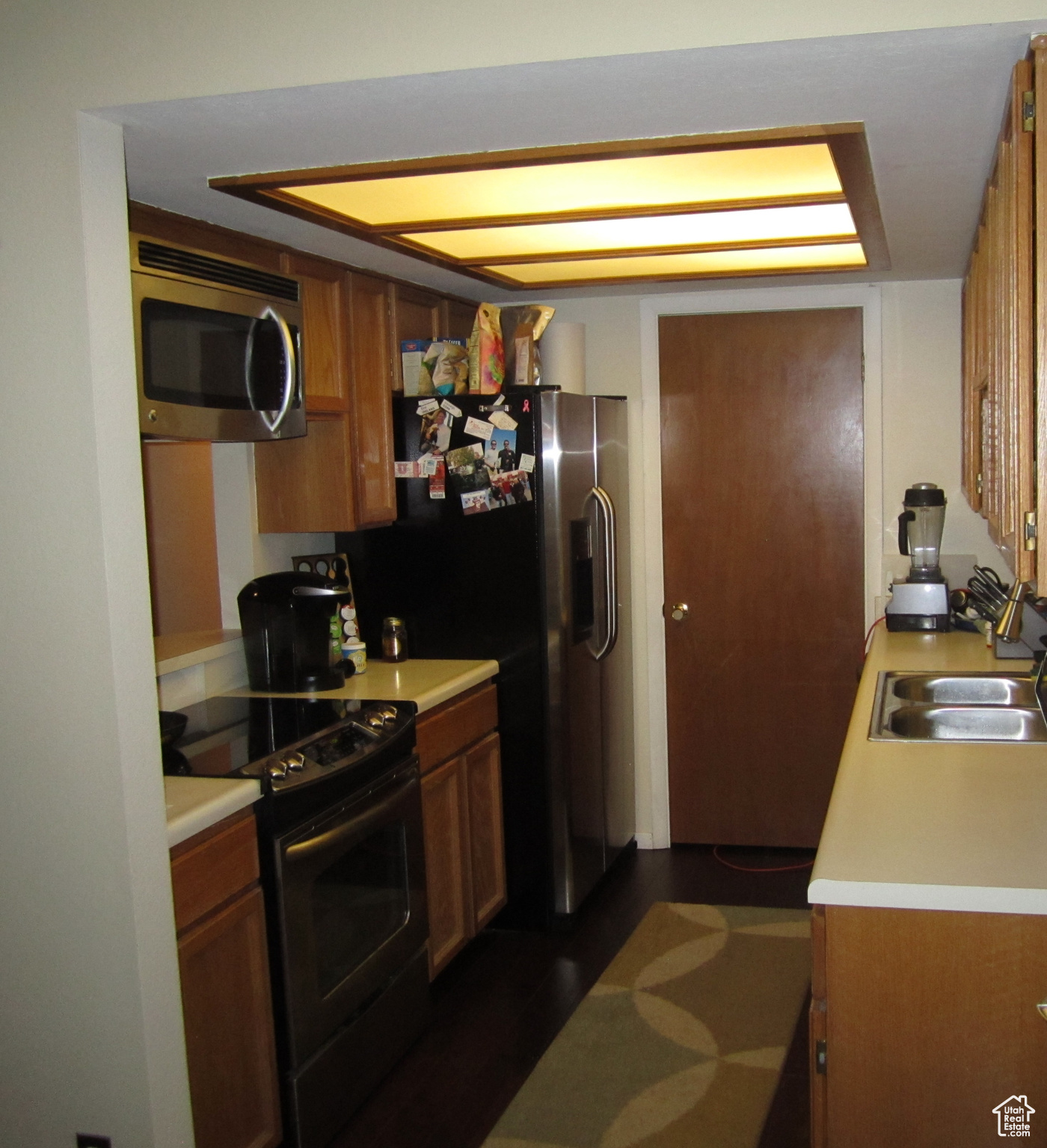 Kitchen featuring electric range, microwave and sink