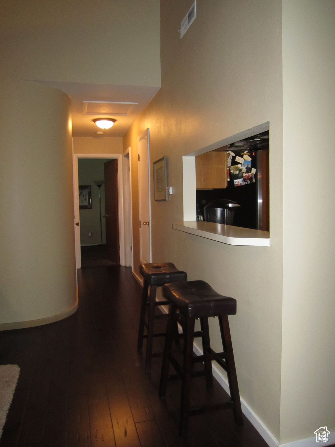 Kitchen and Living room with dark hardwood / wood-style flooring and black fridge