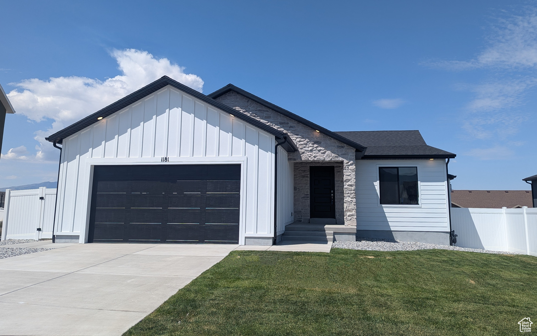 Modern inspired farmhouse featuring a garage and a front yard