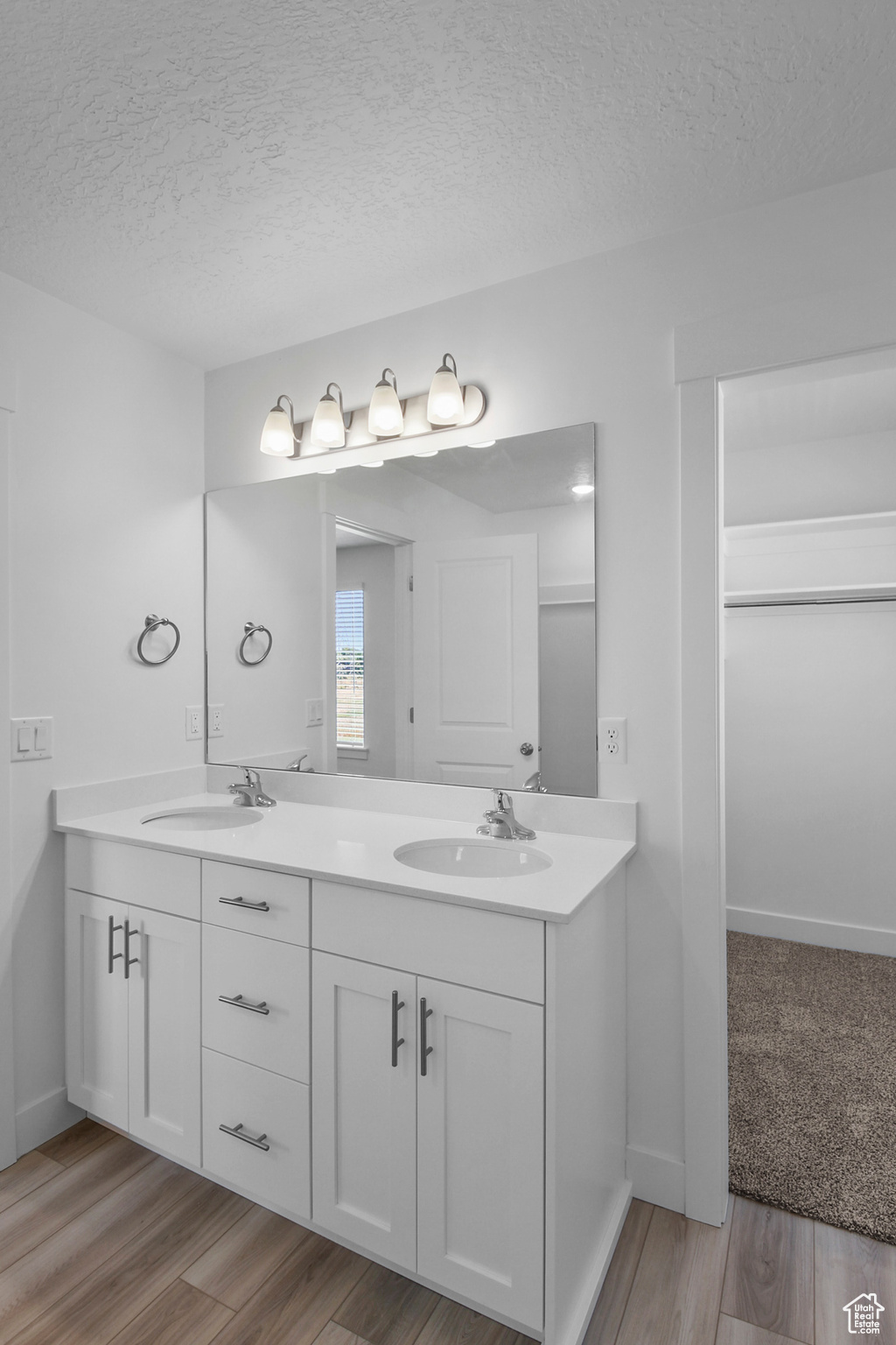 Bathroom featuring hardwood / wood-style flooring, dual vanity, and a window