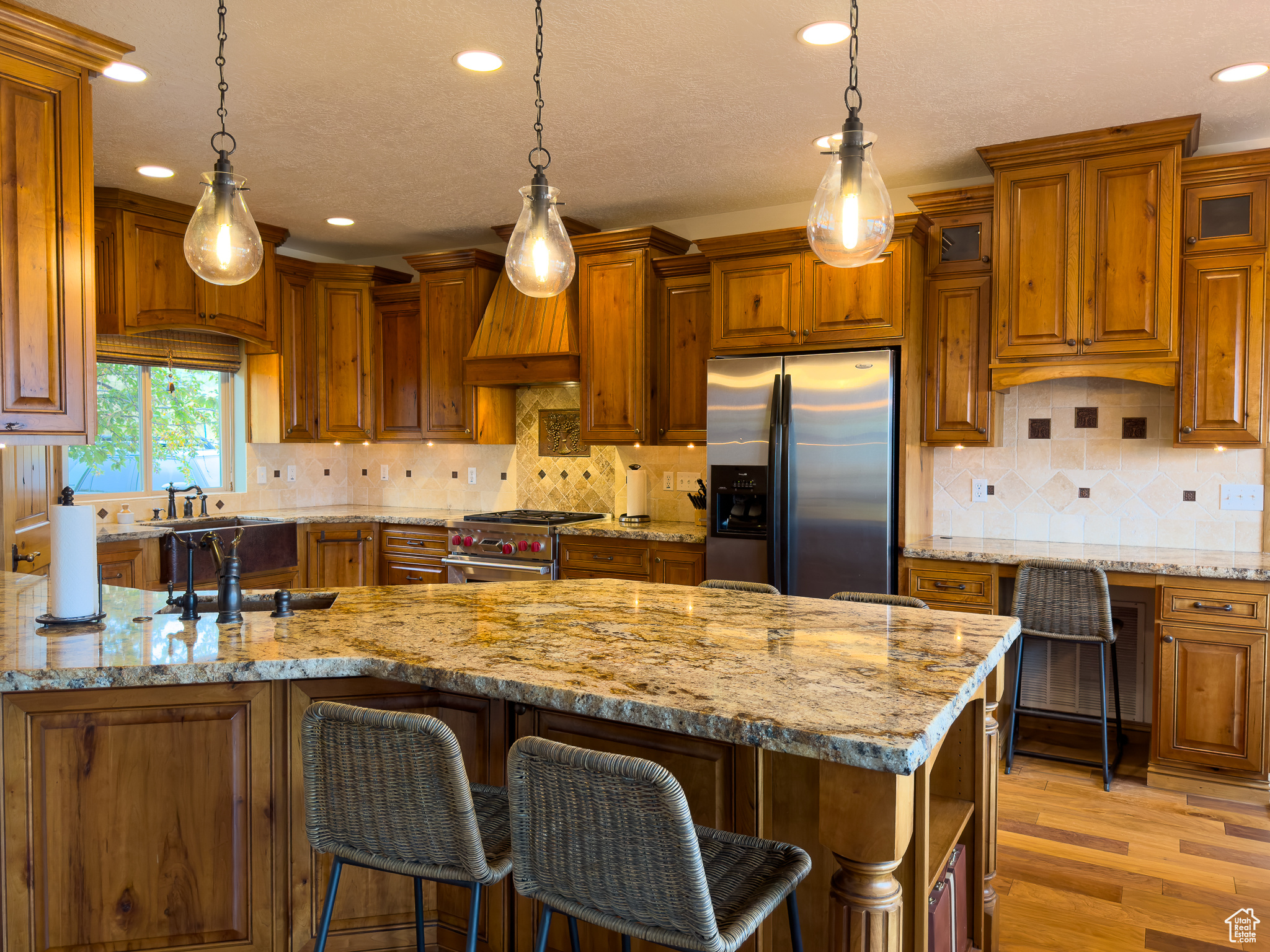 Kitchen with tasteful backsplash, appliances with stainless steel finishes, and pendant lighting