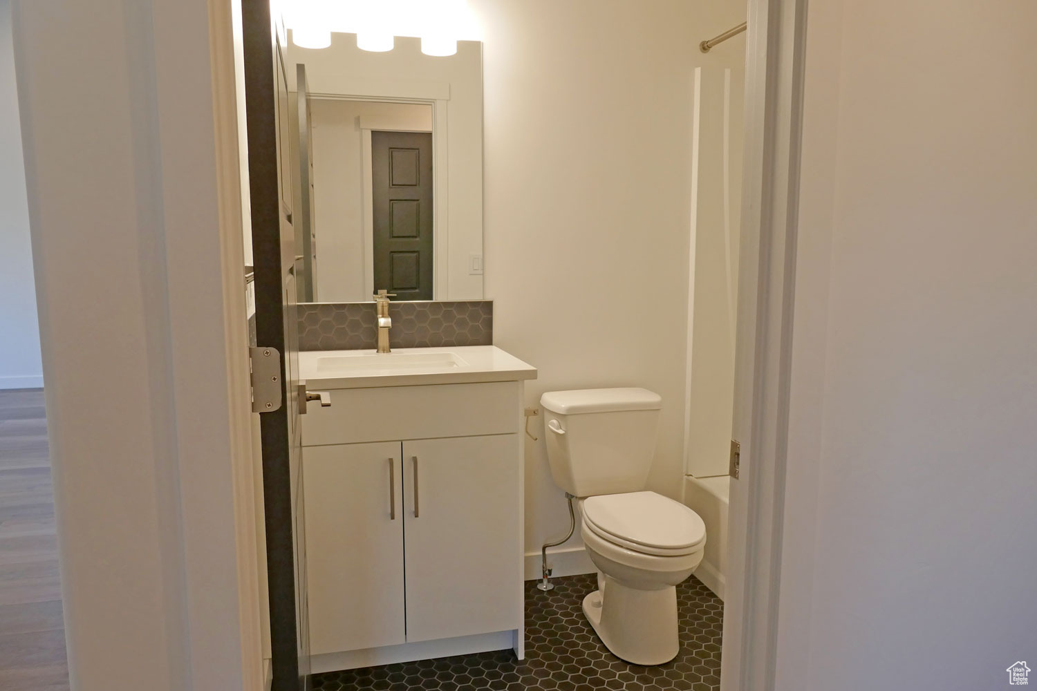 Full bathroom featuring large vanity, tasteful backsplash, toilet, tile flooring, and shower / bathing tub combination