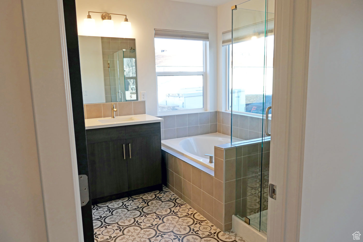 Primary Bathroom with tile floors, large vanity, and separate shower and tub