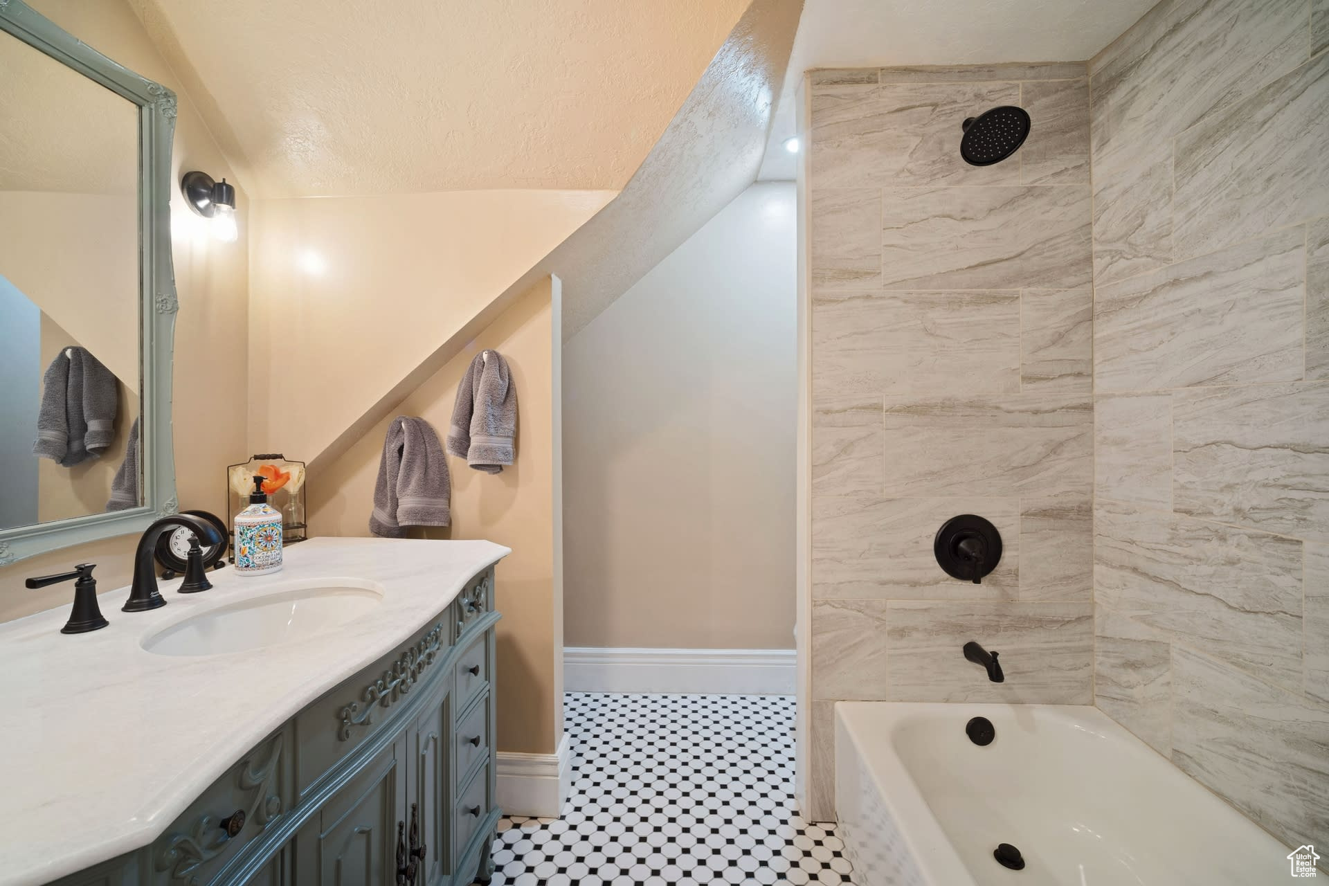 Bathroom with tile floors, tiled shower / bath, and oversized vanity
