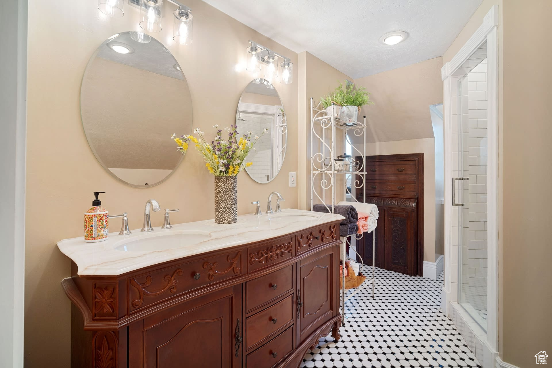 Bathroom featuring dual vanity, walk in shower, and tile flooring
