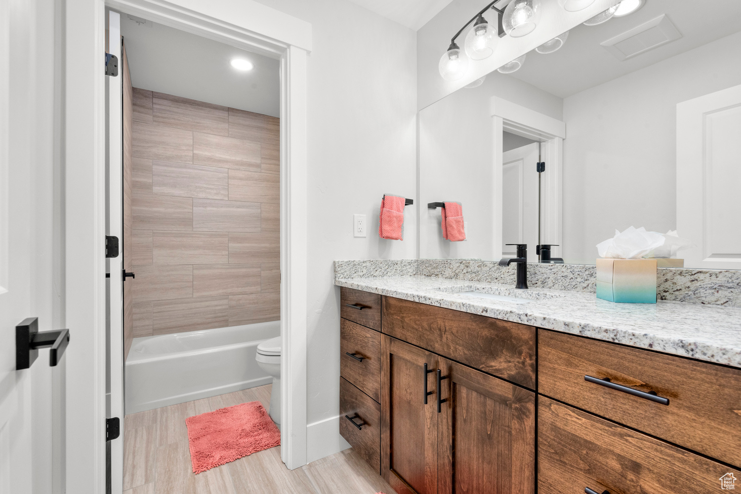 Full bathroom with vanity, toilet, and tiled shower / bath combo