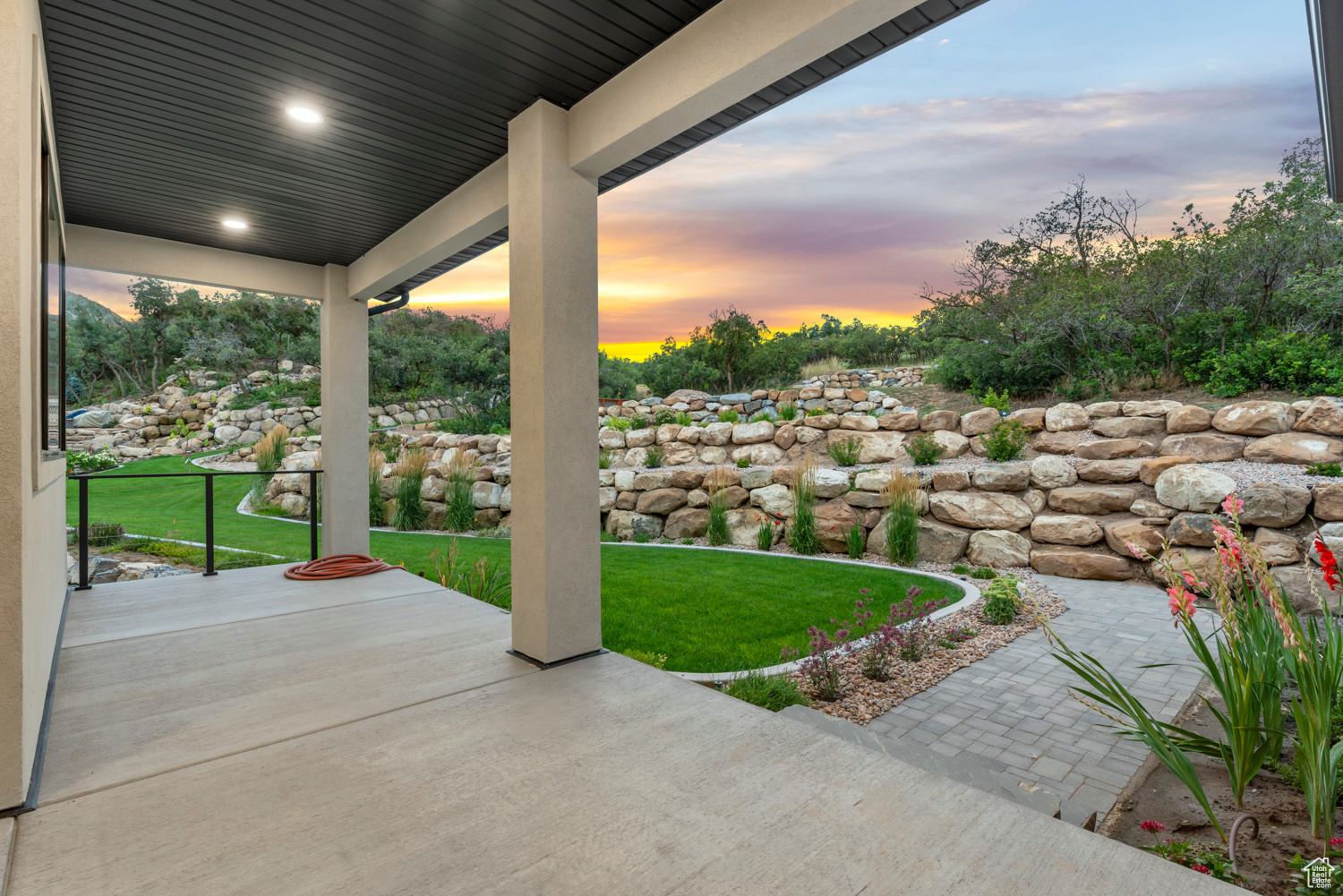 Patio terrace at dusk featuring a yard