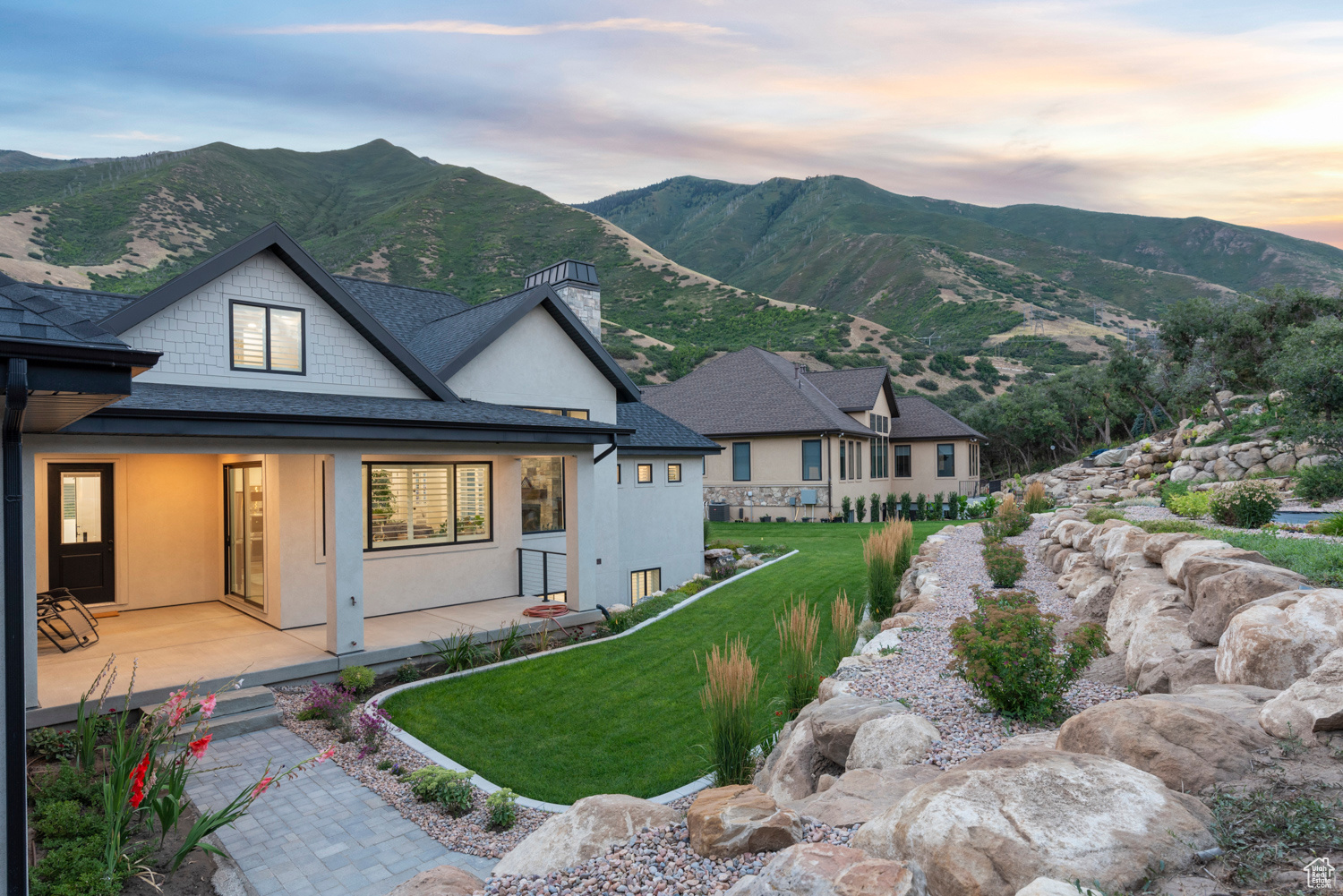 View of front facade with a mountain view, a lawn, and a patio