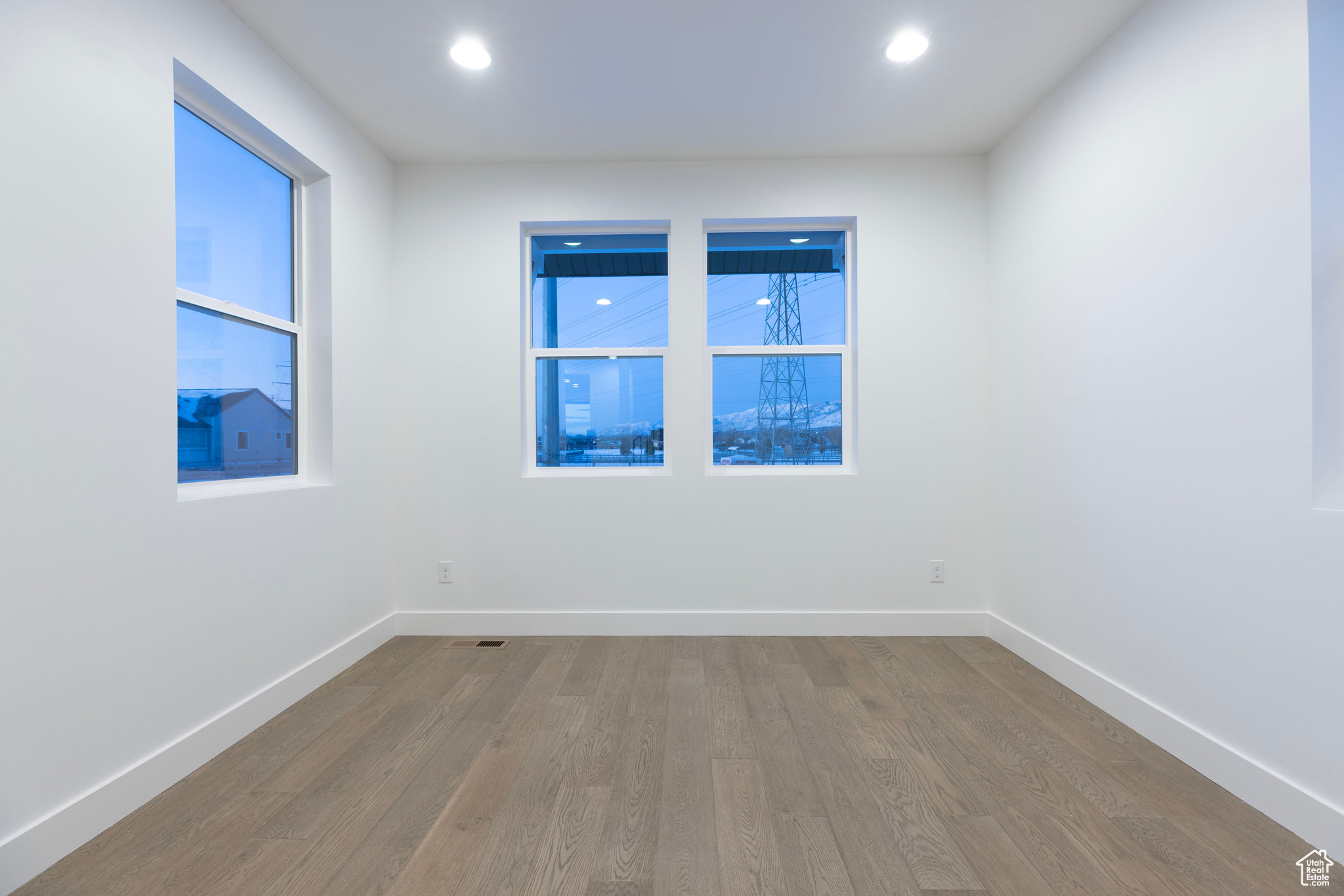 Empty room with hardwood / wood-style floors and a healthy amount of sunlight