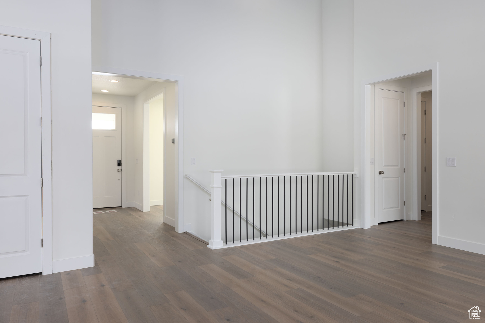 Unfurnished room featuring a towering ceiling and dark wood-type flooring