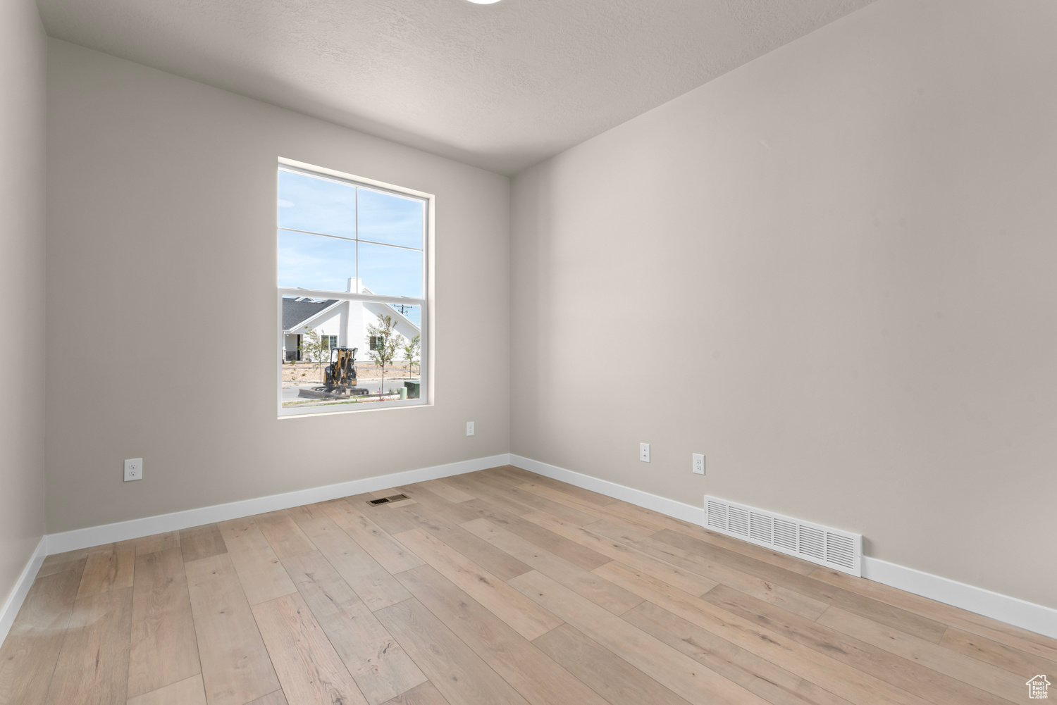 Empty room with plenty of natural light and light hardwood / wood-style flooring