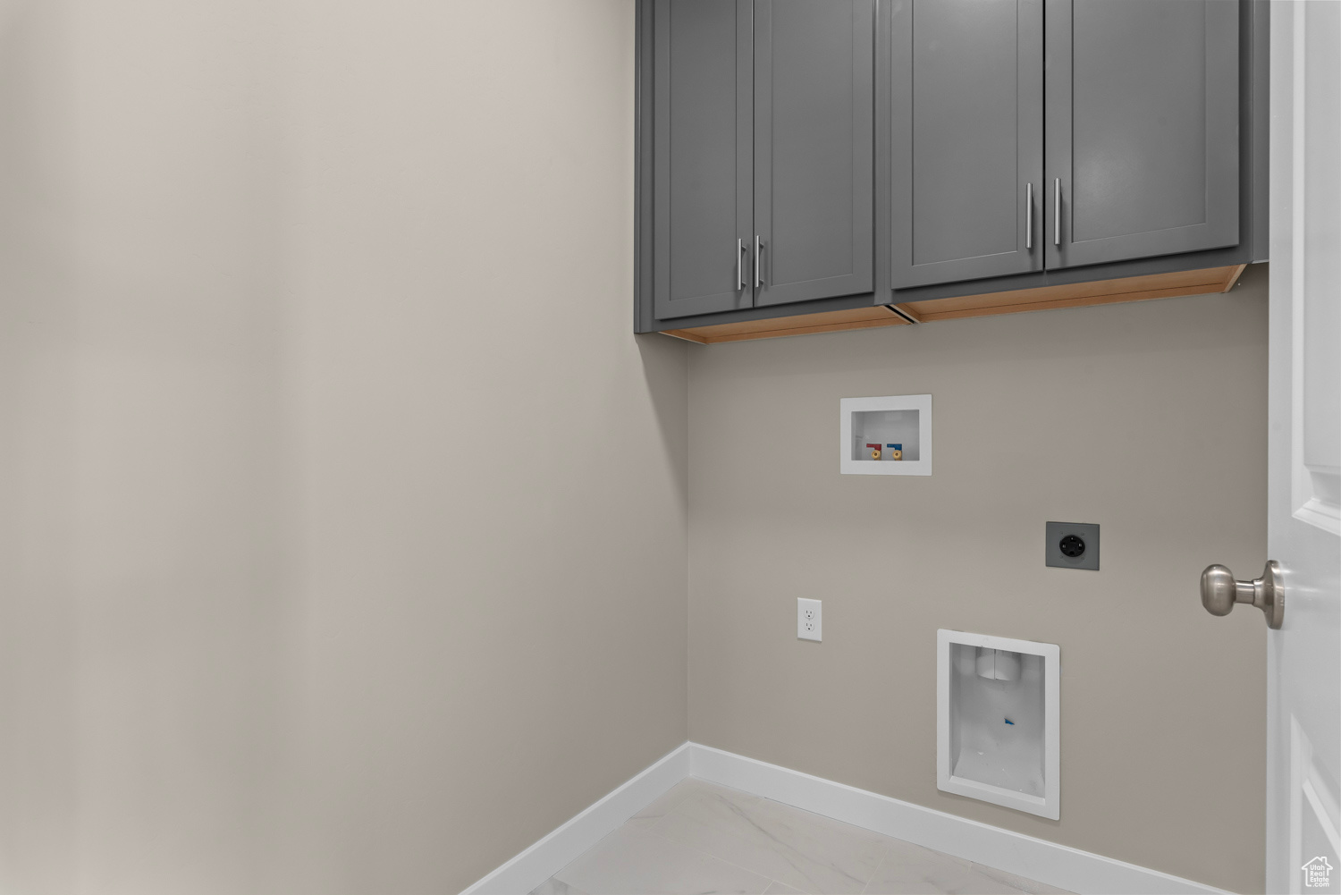 Clothes washing area with cabinets, hookup for an electric dryer, and hookup for a washing machine