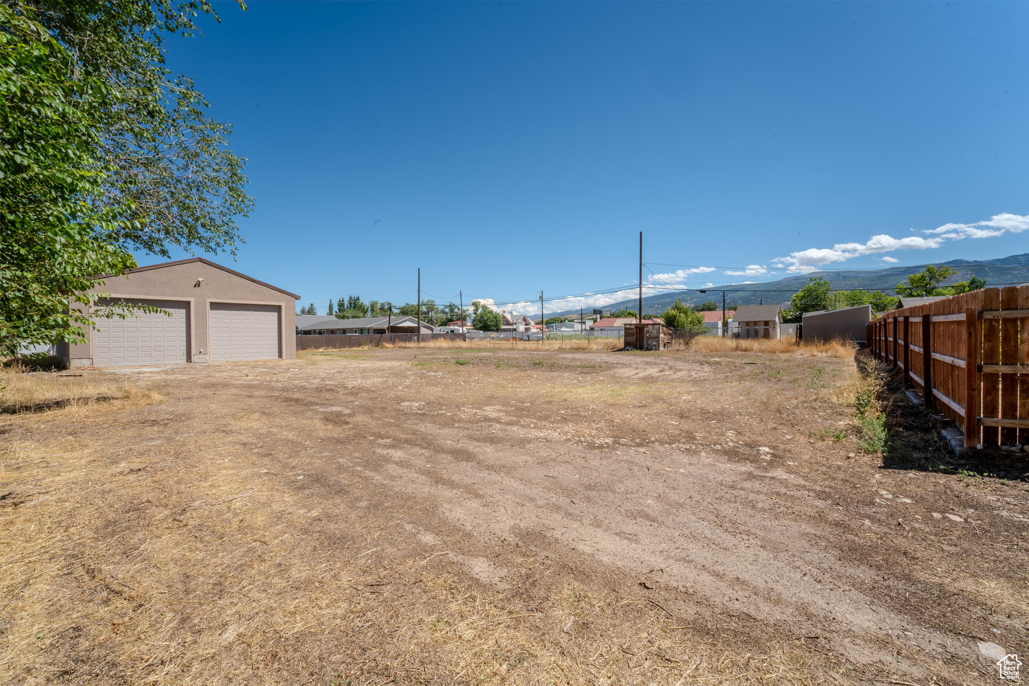 View of yard featuring a mountain view, an outbuilding, and a garage