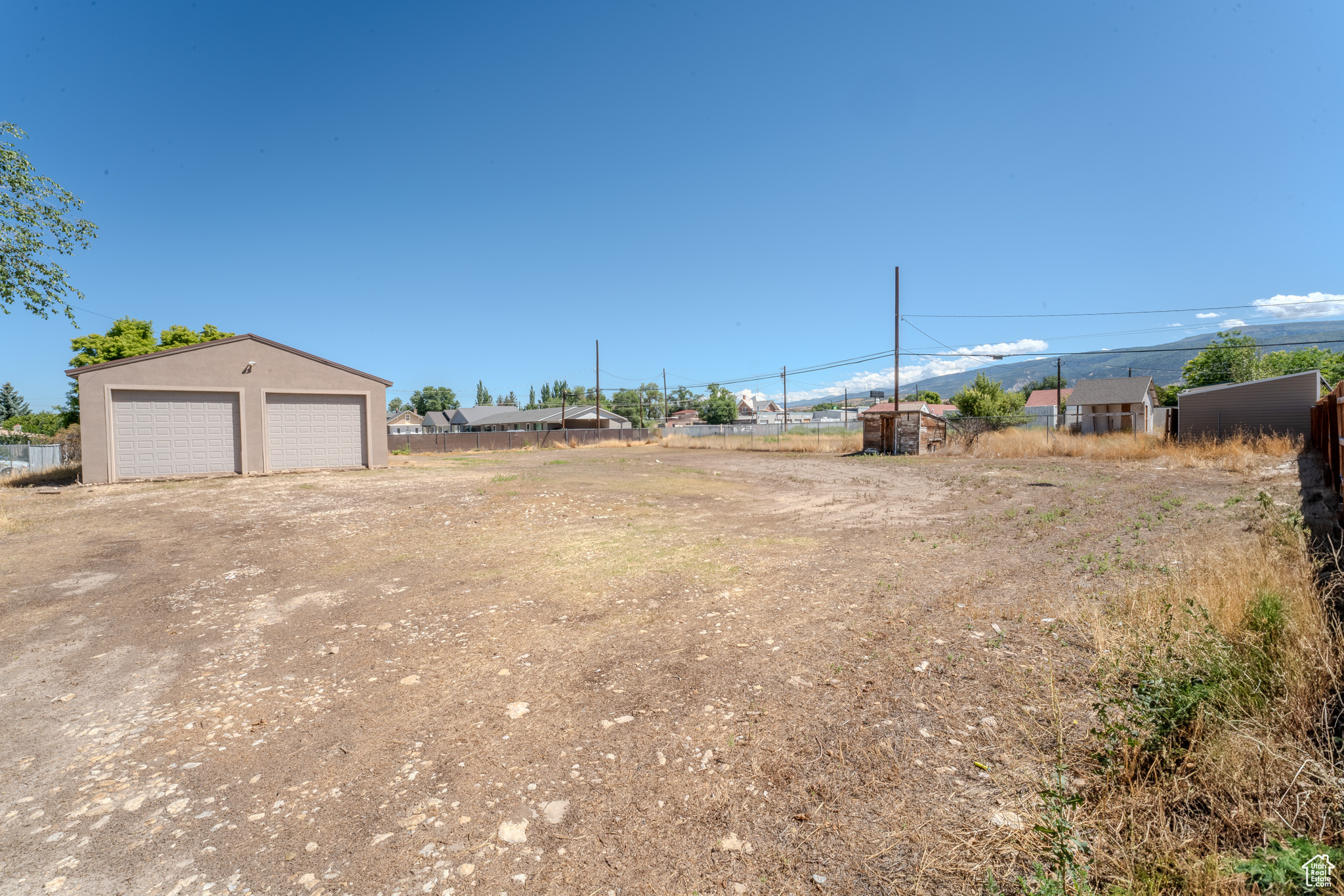 View of yard featuring a garage and an outbuilding