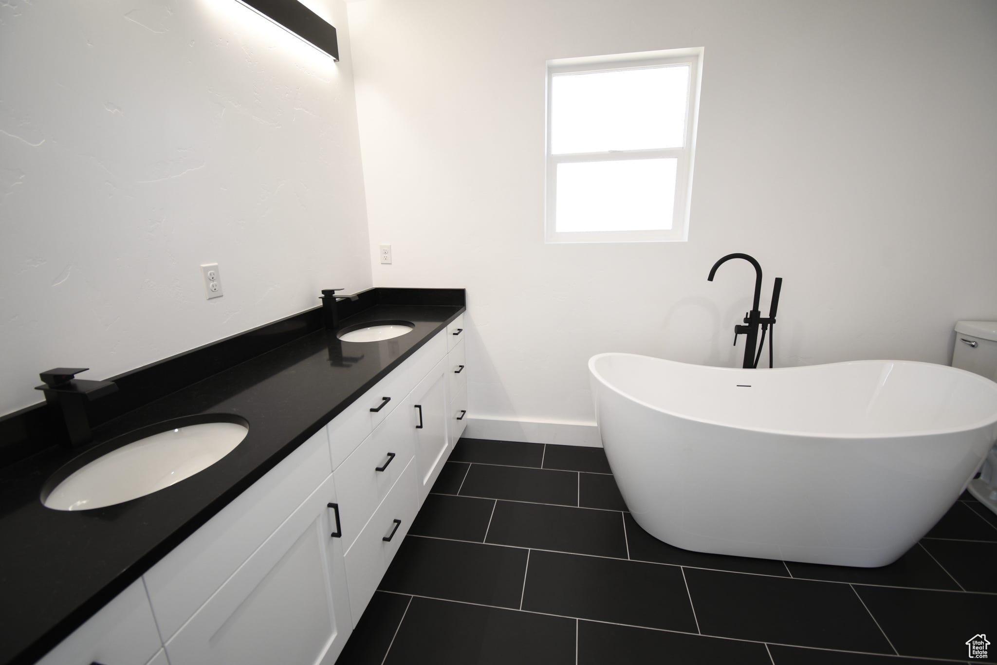 Bathroom featuring tile flooring and dual vanity