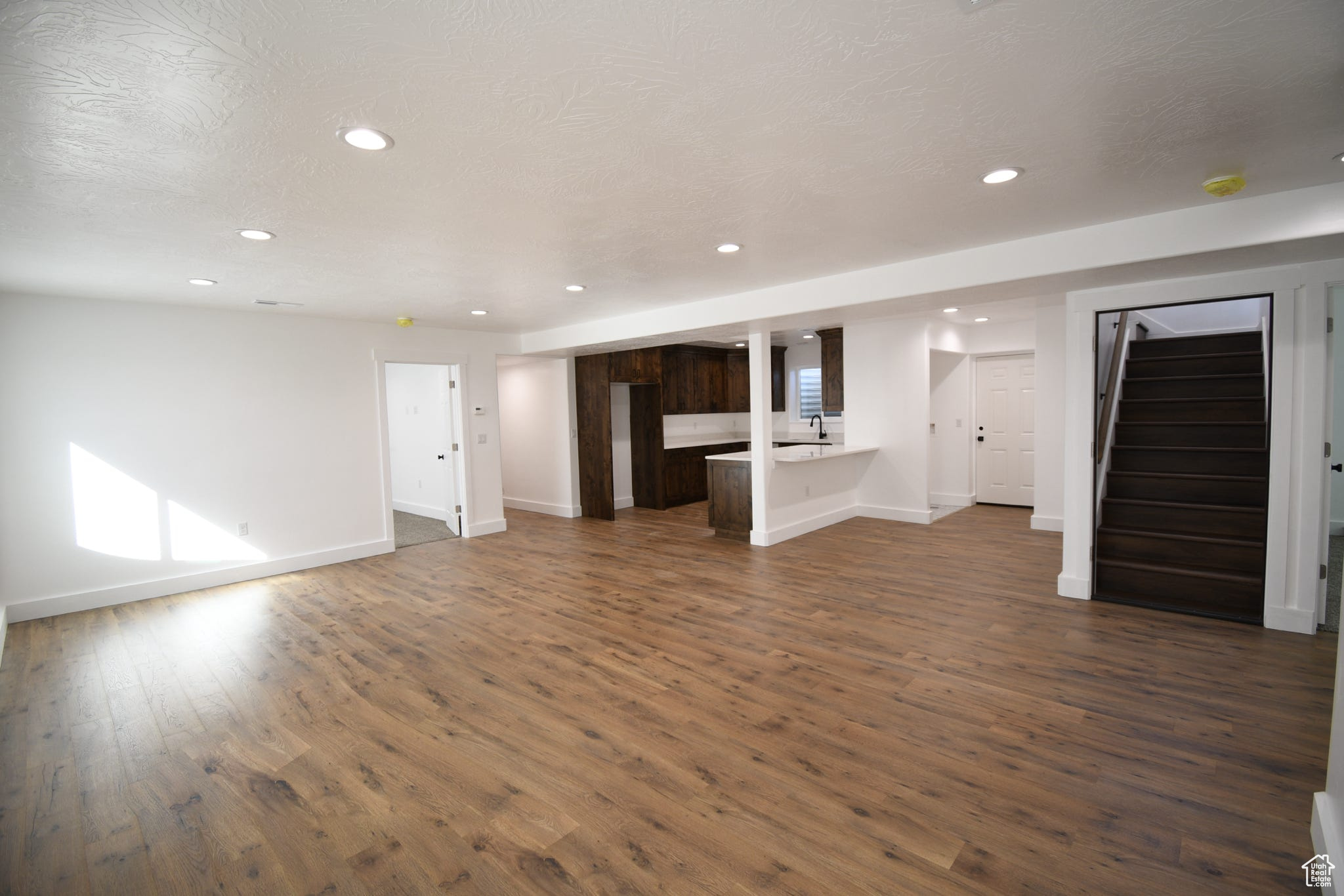 Unfurnished living room featuring dark wood-type flooring