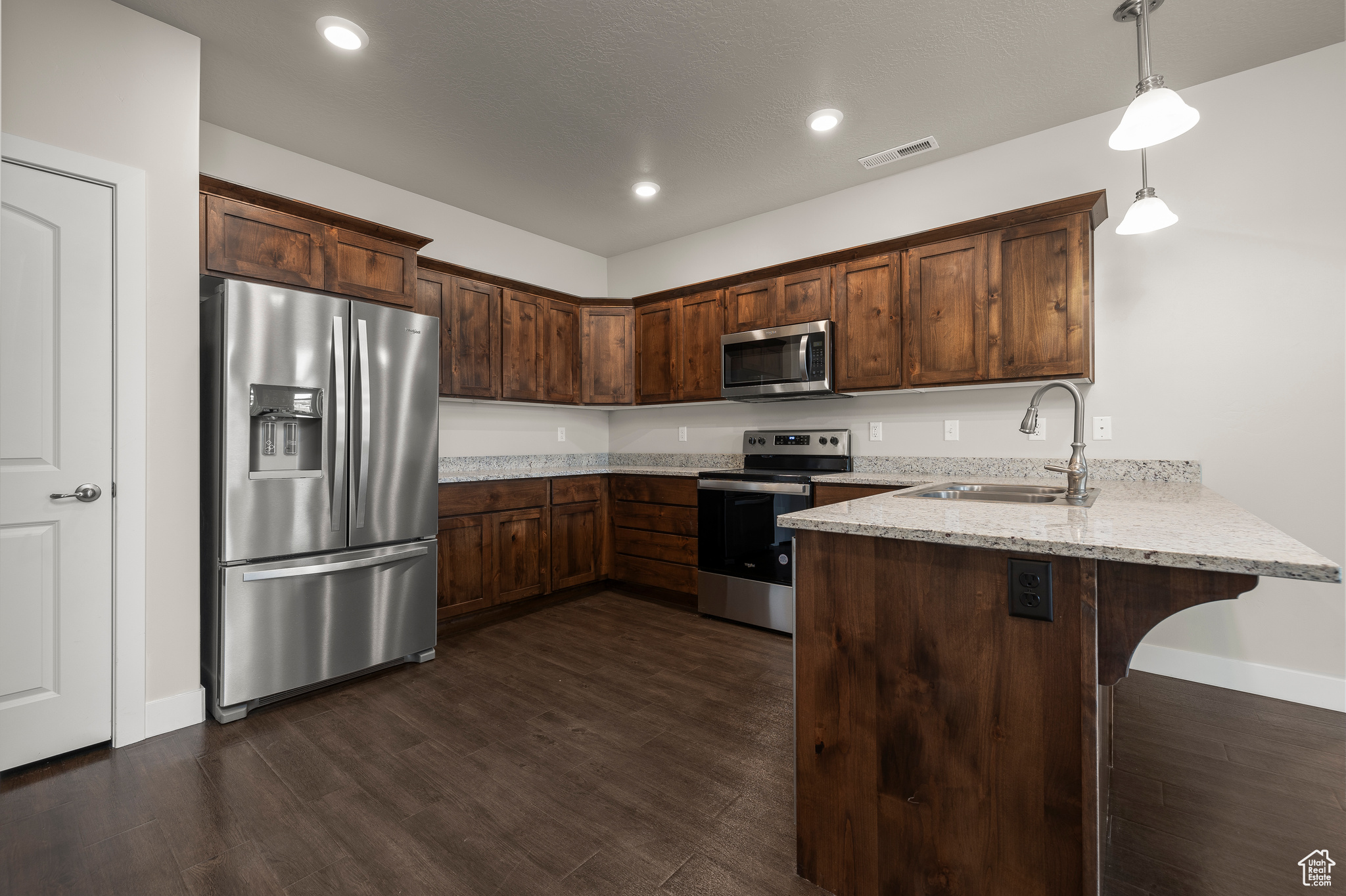 Kitchen with stainless steel appliances and granite counters. Fridge included!