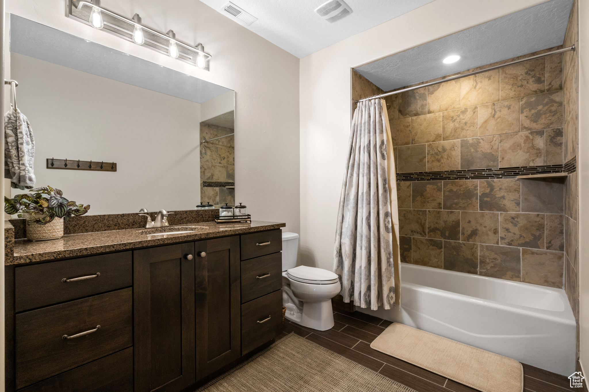 Full bathroom with vanity, toilet, shower / bath combo, and tile floors