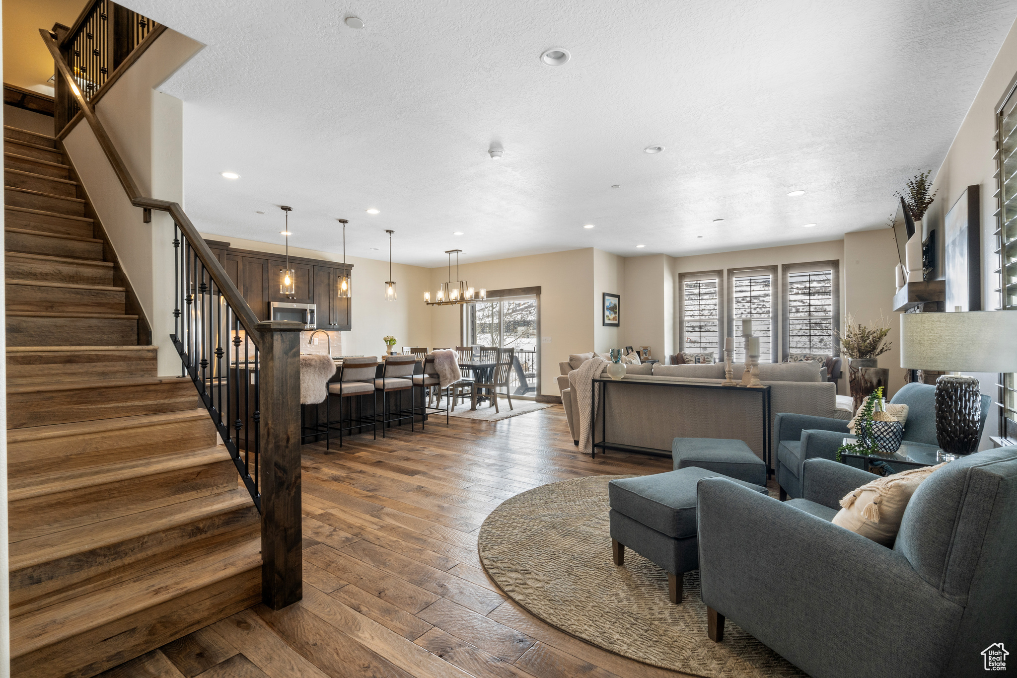 Living room with dark hardwood / wood-style flooring and a notable chandelier