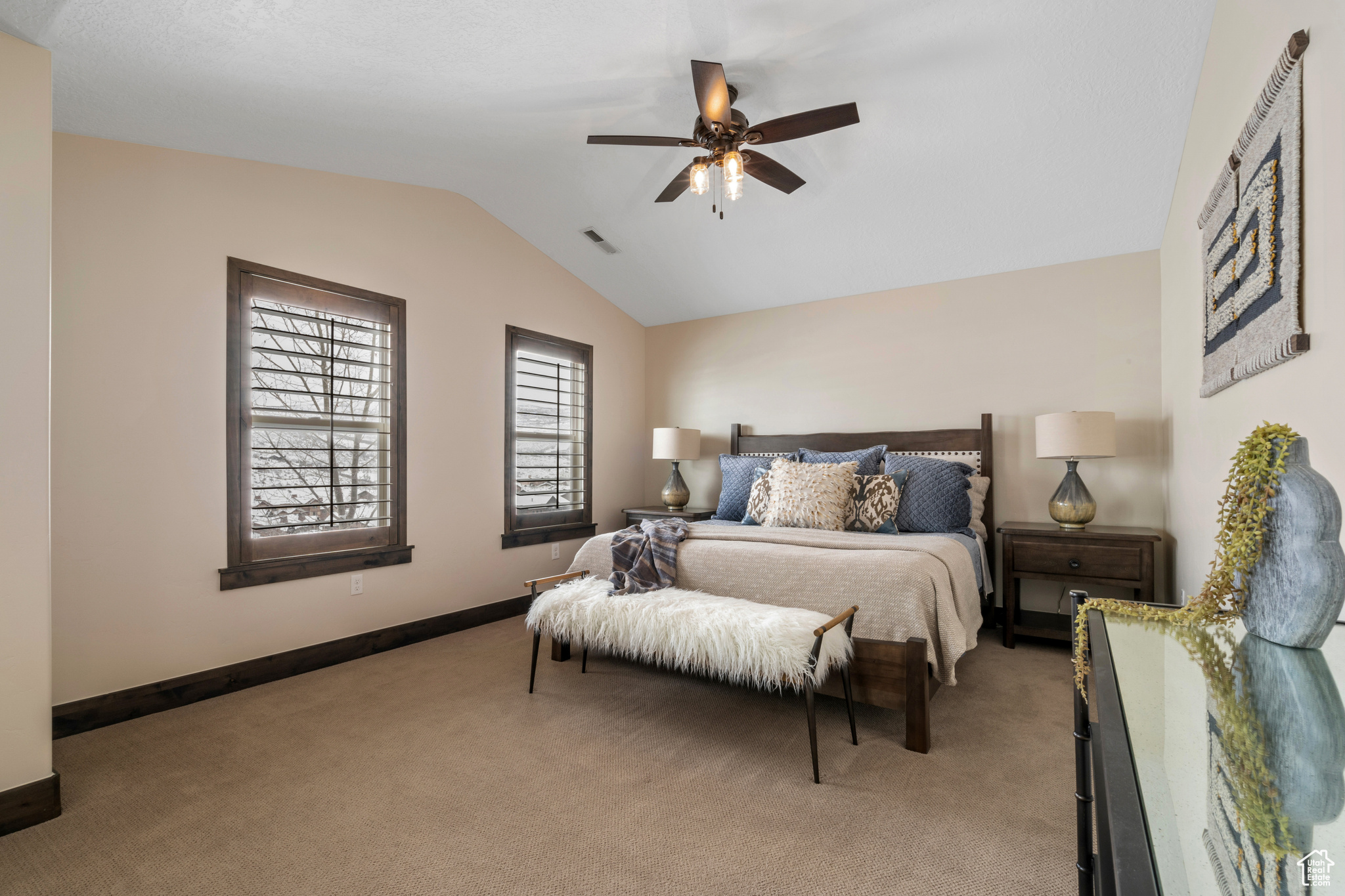 Carpeted bedroom with vaulted ceiling and ceiling fan