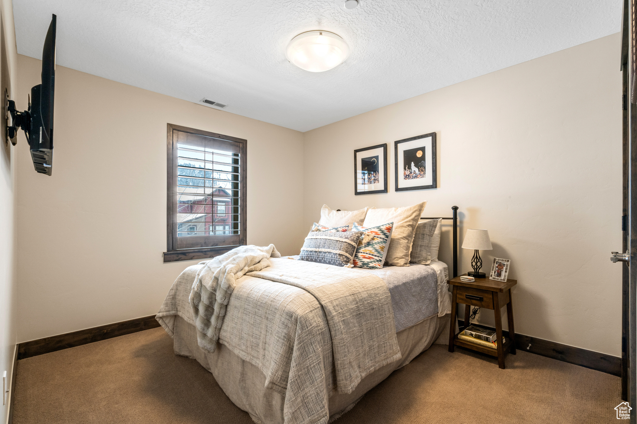 Bedroom featuring a textured ceiling and dark colored carpet