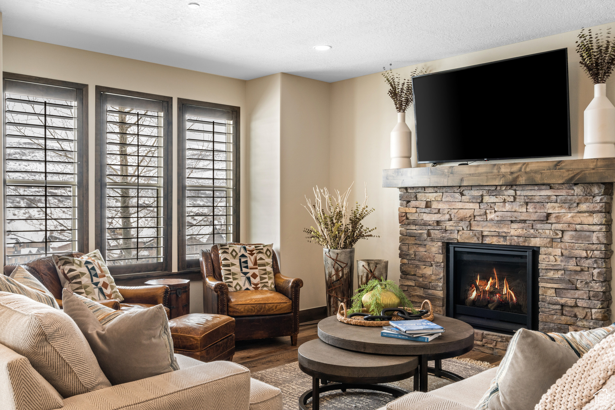 Living room featuring a textured ceiling, dark hardwood / wood-style floors, a fireplace, and a wealth of natural light