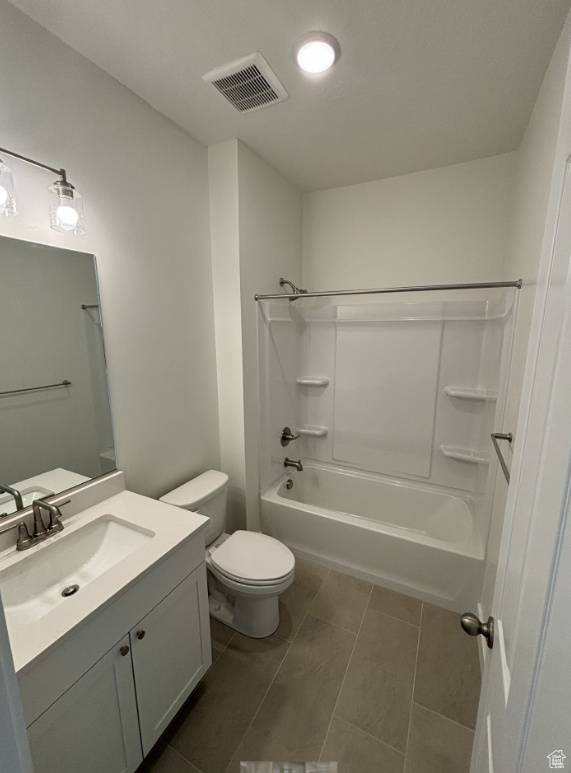 Full bathroom featuring tile floors, toilet, vanity, and bathing tub / shower combination